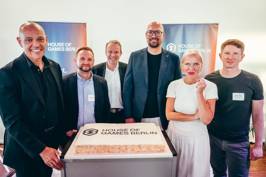 Personengruppe um eine Torte mit Logo und Schriftzug