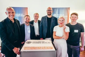 Personengruppe um eine Torte mit Logo und Schriftzug