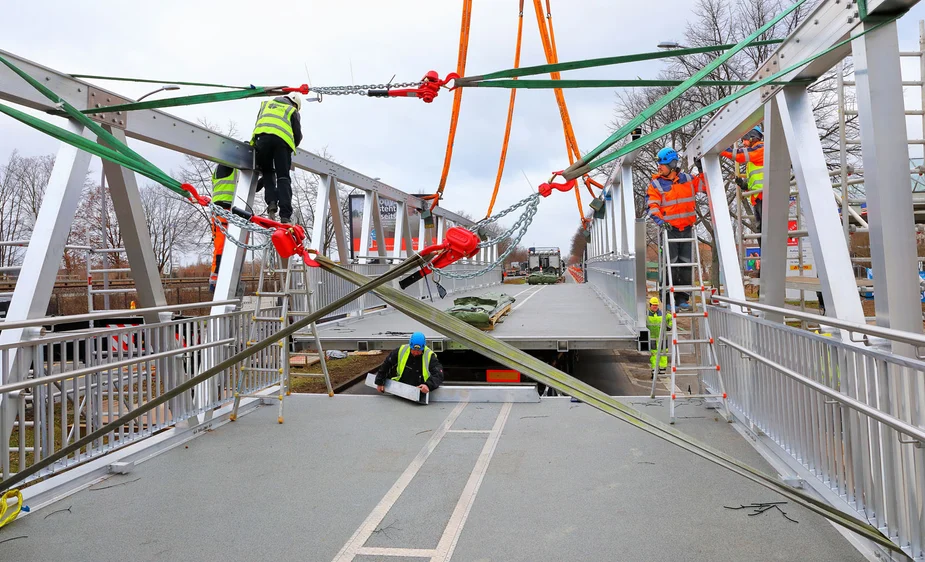 Die Brückenteile werden zusammengebaut und sind mit vielen Spanngurten fixiert.