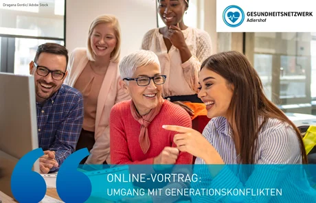Mehrere Personen sitzen vor einem Desktop. Die ältere und jüngere Frau im Vordergrund lachen.