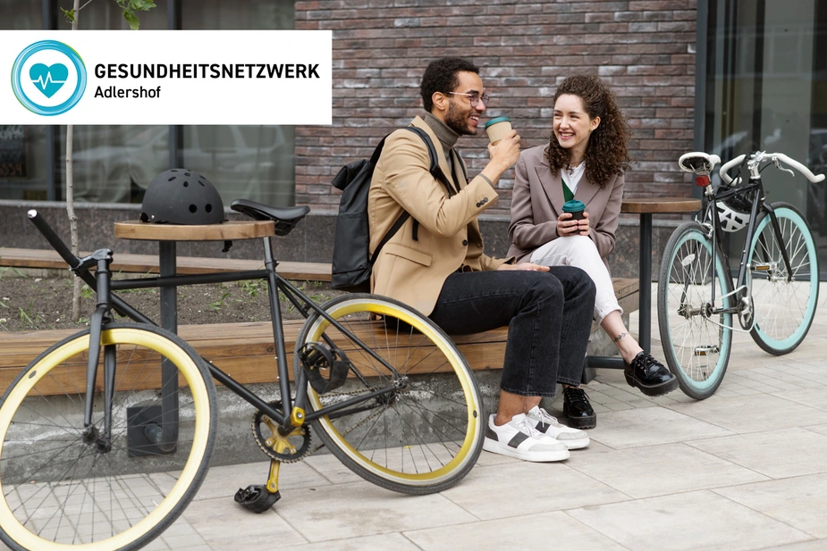 Zwei Menschen mit ihren Fahrrädern auf einer Bank
