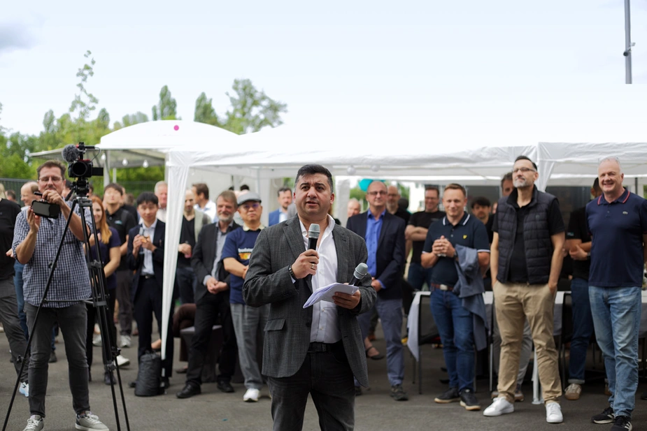 Mann mit Mikrofon vor Gästen