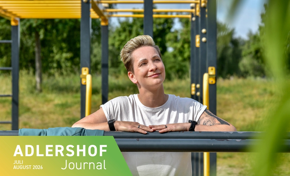 A woman is leaning against a metal bar at an outdoor exercise area