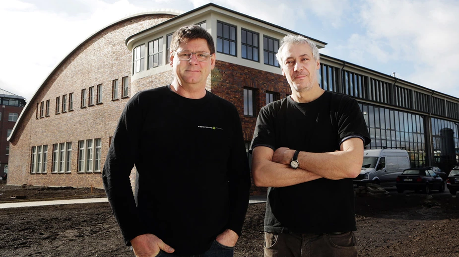 Filmemacher Stephan Horst (l.) und Marcel Neumann vor dem Hangar in der Ludwig-Boltzmann-Straße, in dem das neue Studio entsteht. Bild: © Adlershof Journal