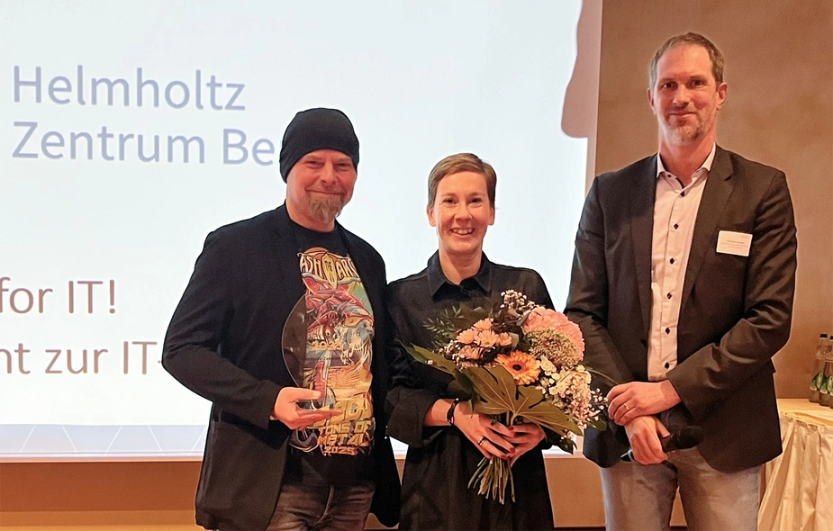 Preisträger mit Trophäe und Blumen