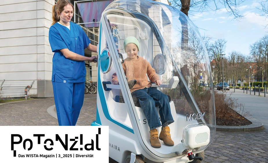 Child in a mobile protective pod being pushed by medical staff.